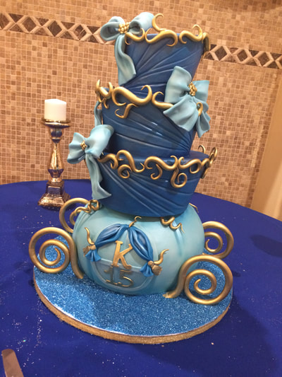 Quinceanera cake 4 tiers made to look like a carriage light blue and dark blue and blue crystals on bottom for some bling.
